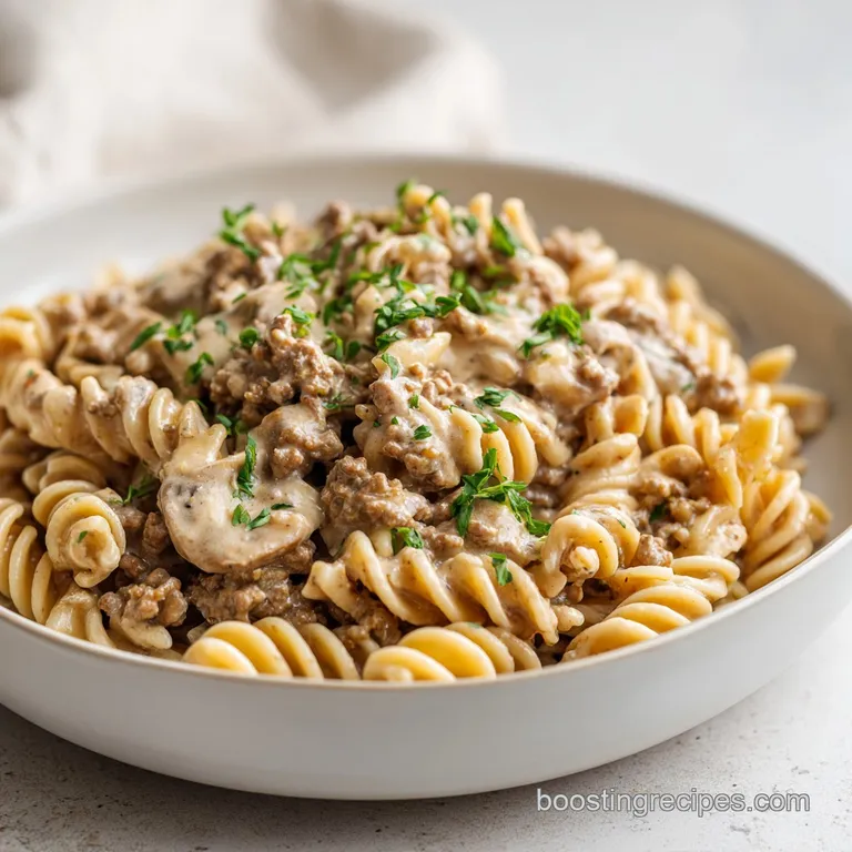 A creamy swirl of stroganoff with tender beef pieces, topped with fresh green chives on a rustic plate.